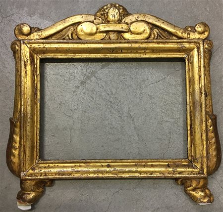 Cartagloria in legno intagliato e dorato con cimasa decorata a volute. Secolo...