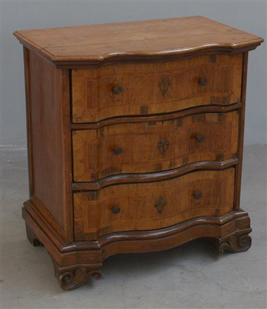 Antico comoncino in noce con fronte mossa a tre cassetti filettati, piedi a...