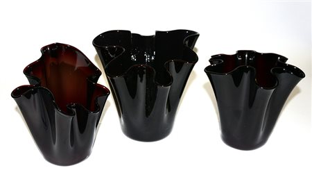 Lotto composto da tre vasi a fazzoletto in vetro nei toni del bordeaux (h max...