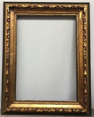 Grande cornice in legno intagliato e dorato a motivi fogliacei con pannello...