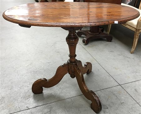 Tavolo a vela in noce con piano di forma ovale, gamba a colonna poggiante su...