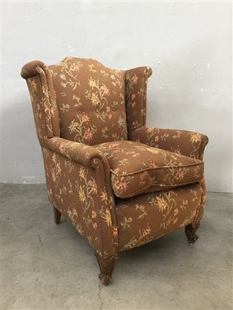 Poltrona a orecchioni con gambe anteriori mosse, rivestimento in tessuto...