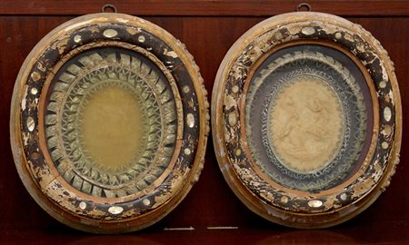 Lotto di due altorilievi in cera a soggetto sacro in cornici ovali del secolo...