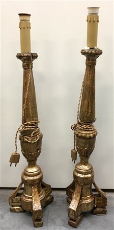 Coppia di torciere in legno laccato e dorato con fusto a colonna e base...