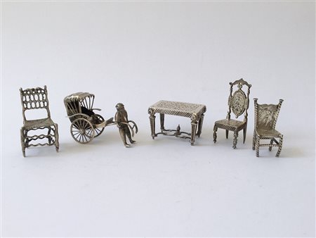 Lotto composto da cinque piccoli oggetti in argento: un tavolino, tre sedie e...