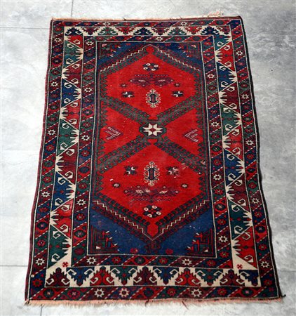 Tappeto Caucasico, secolo XX. Decoro geometrico su fondo rosso (cm 194x120)...