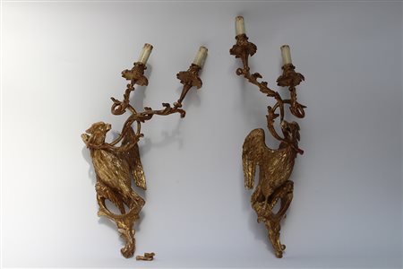Coppia di appliques a due fiamme in legno dorato con corpi scolpiti ad aquile...