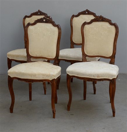 Gruppo di quattro sedie in noce con cimasa scolpita a motivi vegetali, fasce...