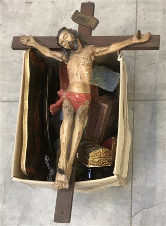 Lotto composto da un crocifisso in legno policromo ed un cartone contenente...