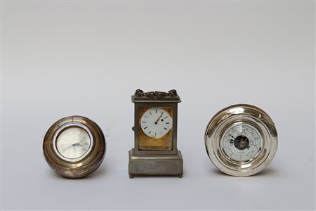 Lotto composto da due orologi da tavola ed un barometro in lamina d'argento e...