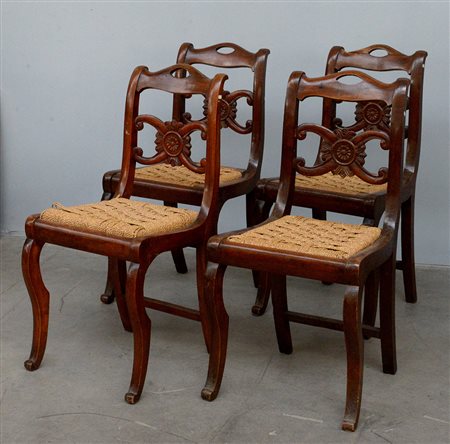 Gruppo di quattro sedie in noce con schienale a giorno decorato da cartella...