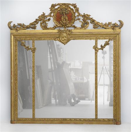 Caminiera tripartita in legno intagliato, dorato e bulinato decorata a motivi...