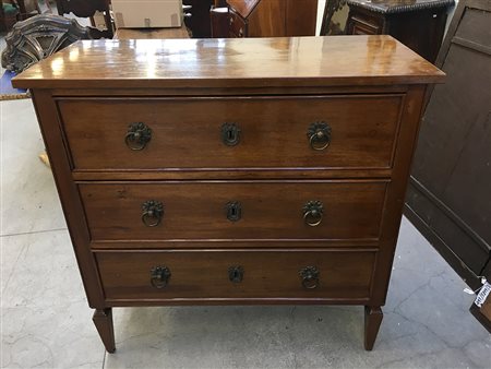 Cassettone lastronato in mogano a tre cassetti. Piedi ad obelisco rovesciato...