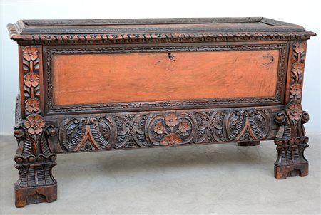 Grande cassone in legno con decori intagliati e tinti a fori e volute,...