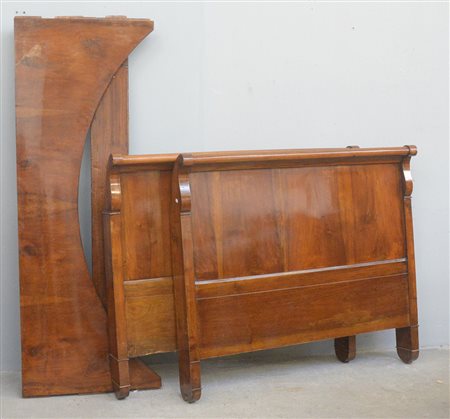 Letto a barca lastronato in mogano con terminali intagliati a fiori. Secolo...