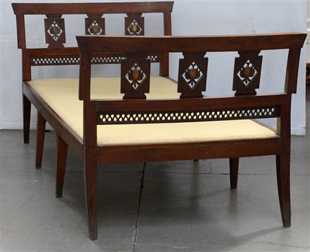 Divanetto in noce con braccioli traforati decorati da placche intagliate e...
