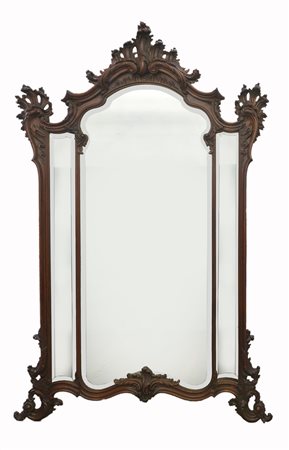 Specchiera di forma sagomata in legno ebanizzato e intagliato a volute e...