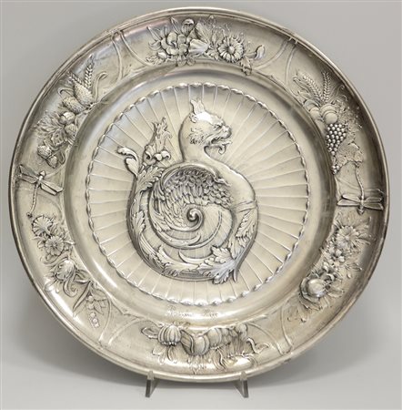 Piatto in argento sbalzato a motivo di animale fantstico con bordo a fiori e...