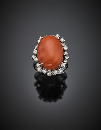 Anello in oro bianco, diamanti per complessivi ct. 0,80 circa e corallo ovale...