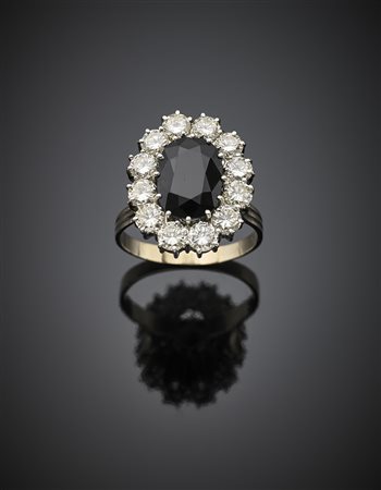 Anello in oro bianco con zaffiro a cuscino di ct. 7 circa e diamanti rotondi...