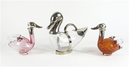 Lotto di 3 bottiglie in vetro e argento a forma di papere. Lung. max cm. 34.