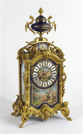 Orologio da caminetto in bronzo dorato abbellito da piastre in porcellana...