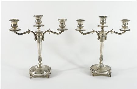 Paio di candelieri in argento a 3 fiamme finemente incisi e sbalzati.Fratelli...