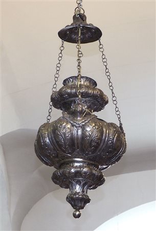 Lampadario in metallo lavorato a sbalzo a motivi floreali e teste di angeli....