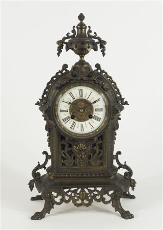 Orologio da tavolo in metallo con quadrante a numeri romani. H. cm. 45.