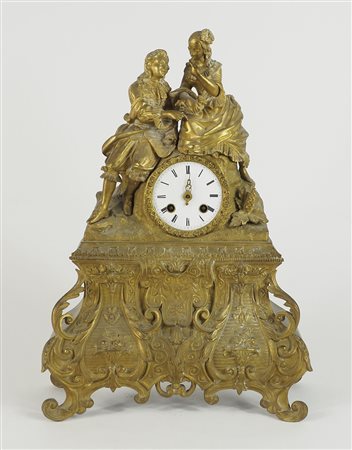 Orologio da tavolo in metallo dorato con figure. H. cm. 45.