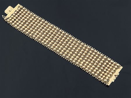 Bracciale in oro giallo a larga fascia. gr. 62,1.