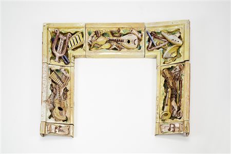 Cornice per camino in ceramica decorata a rilievo con strumenti musicali e...