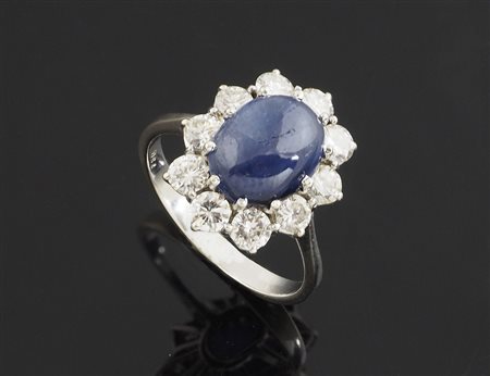 Anello in oro bianco a margherita con diamanti e zaffiro centrale cabochon....