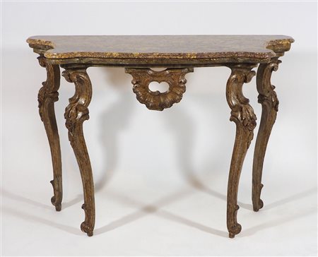 Consolle in legno su alte gambe mosse scolpite, piano sagomato in marmo....