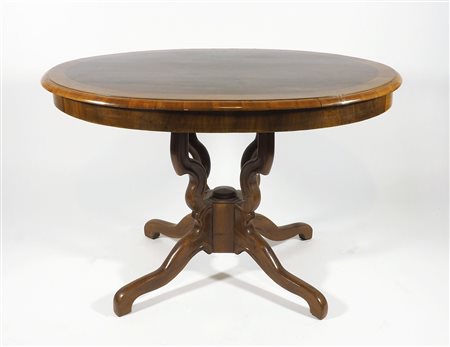 Tavolo ovale in legno su gambe mosse. cm. 78x120x76.