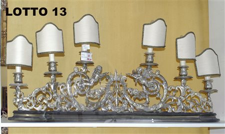 CANDELABRO A 6 LUCI IN METALLO SBALZATO E ARGENTATO SORMONTATO DA DUE PUTTI...