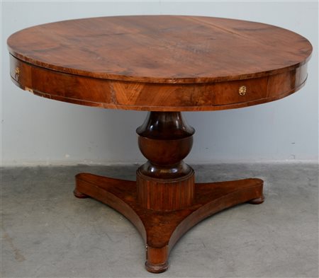 Tavolo tondo a quattro cassetti poggiante su gamba centrale a colonna...