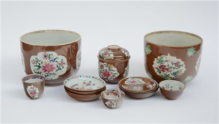 Gruppo di vari oggetti in porcellana a fondo cafè-au-lait a decoro Famiglia...