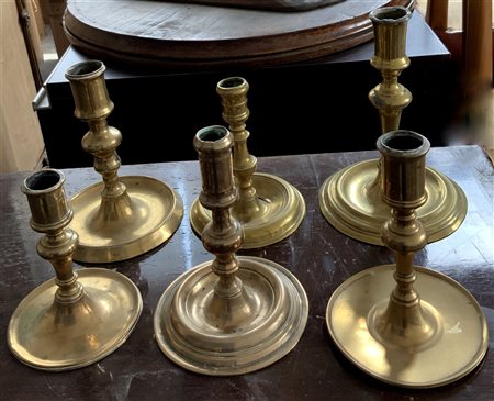 Gruppo di sei candelieri in metallo con basi circolari di fatture differenti...