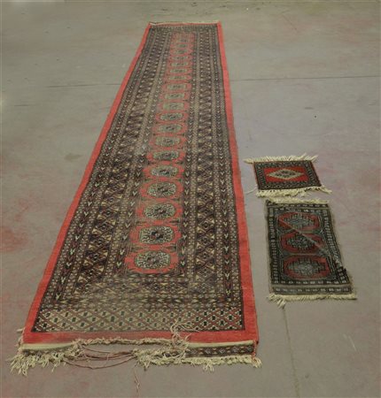 Lotto di tre tappeti Pachistan, secolo XX. (cm 452x78; 63x29; 30x29)...