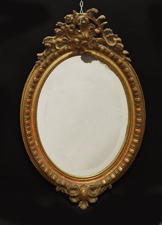 Specchiera con cornice in legno intagliato e dorato, decorata con foglie e...