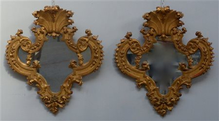 Coppia di specchiere con cornici in legno intagliato e dorato a foglie e...