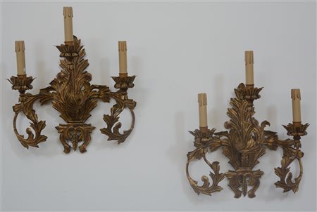 Coppia di appliques a tre luci in metallo dorato a forma di foglie, bracci...