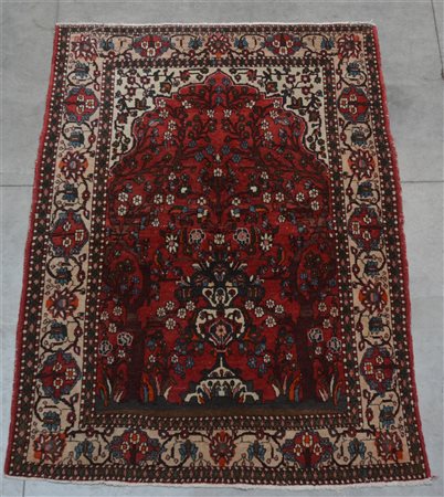 Tappeto preghiera persiano. Mirab a fondo rosso decorato con vaso fiorito...