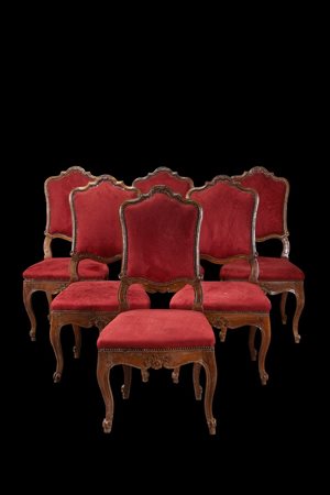 Gruppo di sei sedie in noce con schienale sagomato ed intagliato a volute,...