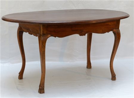 Tavolo di forma ovale in noce con grembiale sagomato e decorato da...