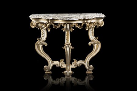 Consolle di forma mossa in legno scolpito, laccato e dorato. Fascia traforata...