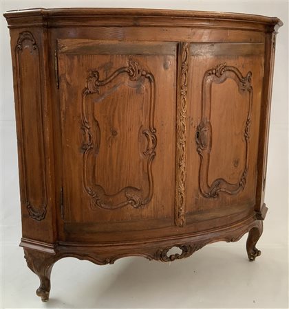 Angoliera in abete a due ante scolpite a volute. Fascia e piedi sagomati....