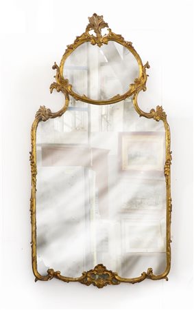 Specchio di forma sagomata in legno intagliato e dorato a volute fogliate (cm...