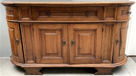 Antica credenza di forma sagomata a tre cassetti sottopiano e quattro ante...